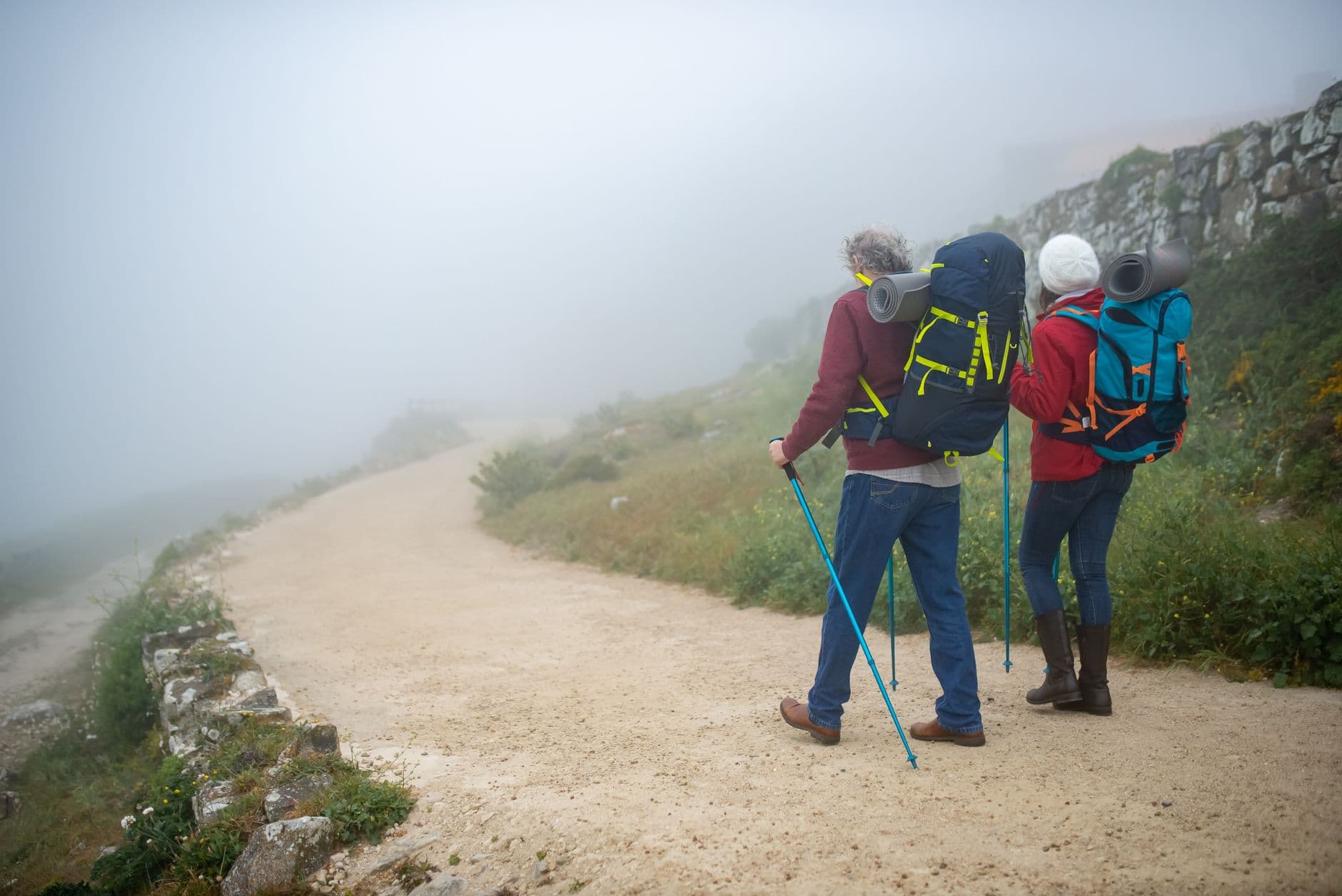 A traveler preparing for a hike in the Caucasus Mountains with a backpack and hiking boots.
