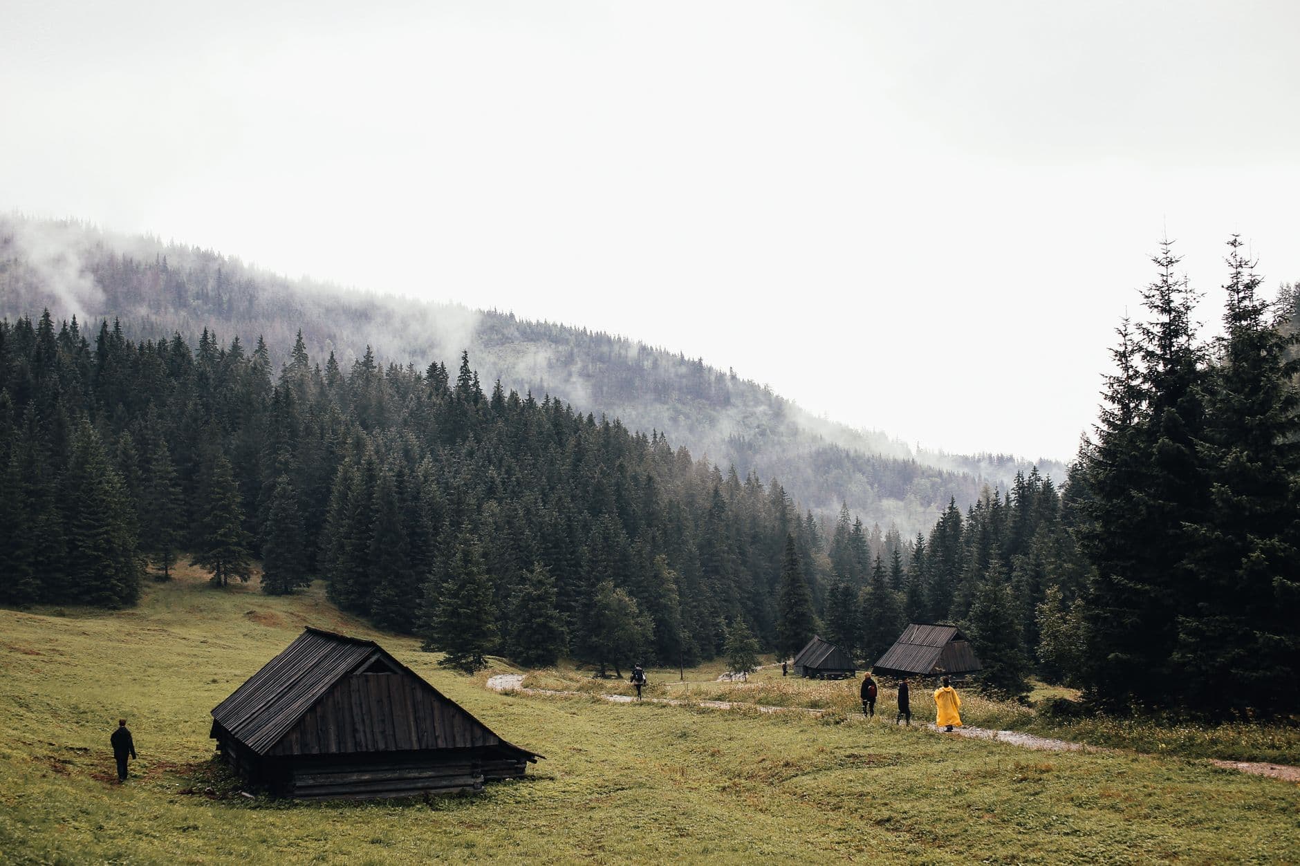 Wooden A-frame cottage against a mountain backdrop in Stepantsminda, offering a panoramic view.